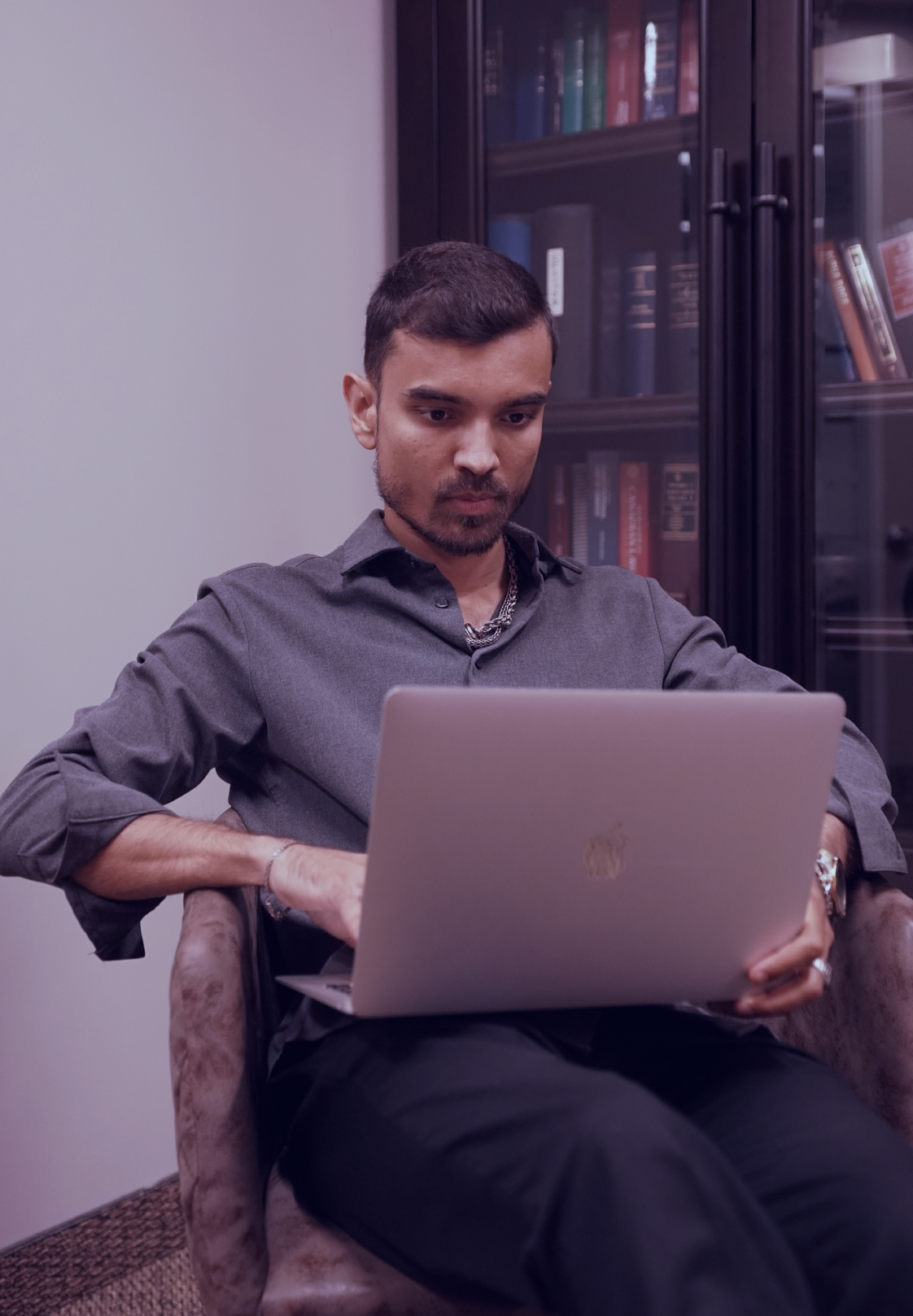a man sitting in a chair looking at a computer screen